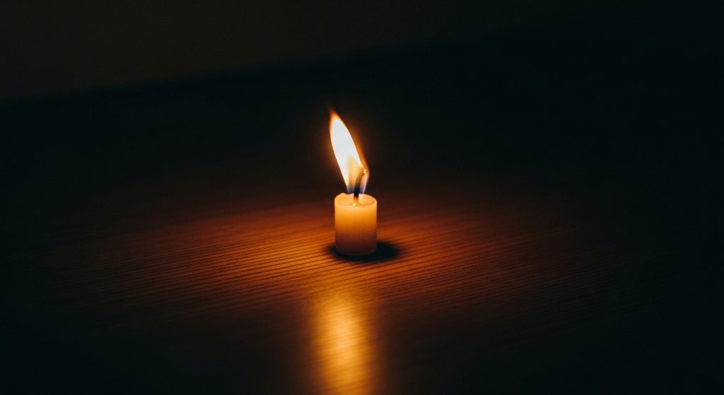 Laptop Wallpaper HD 1080p Aesthetic Vintage Dark Academia Timeless Backgrounds 9 “Minimalist dark academia wallpaper featuring a single flickering candle on a dark wooden table background.”