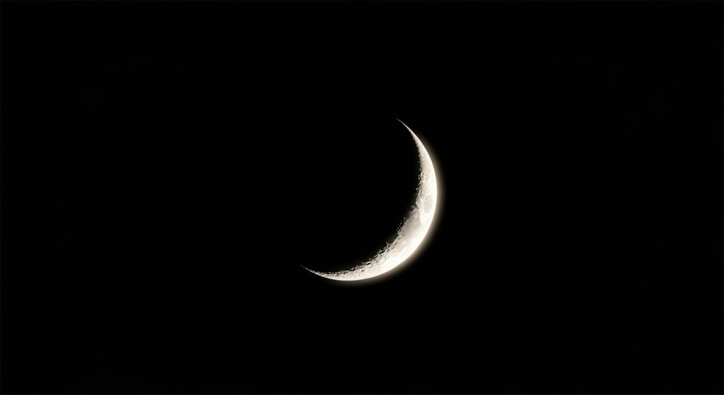 Best Aesthetic Moon Wallpapers for iPhone | Dark & Minimal Backgrounds 9 A sleek crescent moon wallpaper on a black background, minimal and clean.