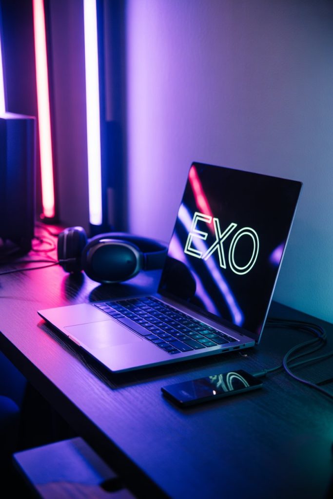 EXO Desktop Wallpaper HD 1080p Dark Aesthetic for Laptop 9 Laptop in a gaming setup glowing with a neon EXO wallpaper, surrounded by RGB lights creating a moody atmosphere.