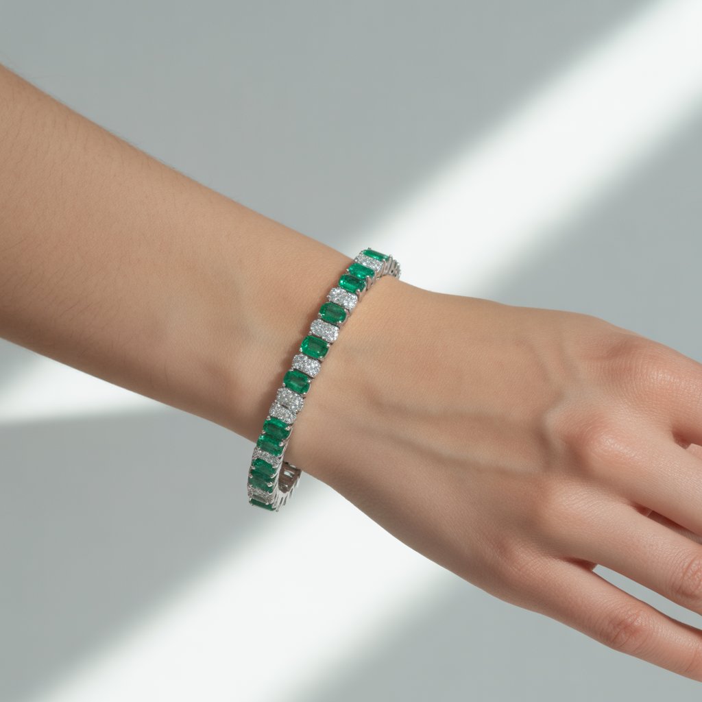 Emerald Jewelry Designs 2025 7 : Sleek wrist shot of an emerald and diamond tennis bracelet on a woman's arm, with alternating green and white gems catching the light, against a minimalist white background, highlighting precision and shine in a modern, alluring composition.