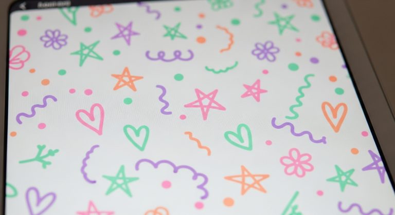 Digital notepad screen decorated with pastel doodles in pink, lavender, mint, and peach, creating a soft and aesthetic wallpaper design.