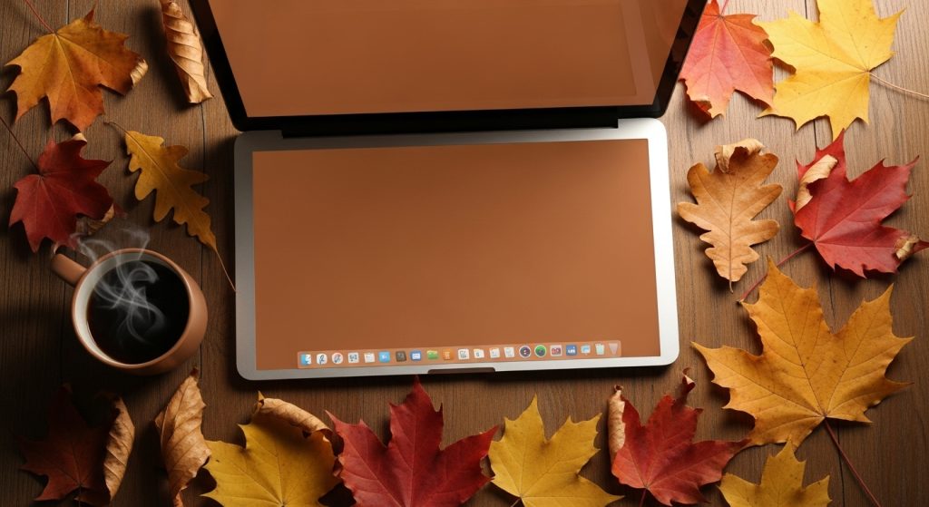 Brown Aesthetic Wallpapers for PC | Warm & Minimal Desktop Backgrounds 3 A flat lay of autumn leaves, a cup of coffee, and a laptop screen with a warm brown wallpaper.
