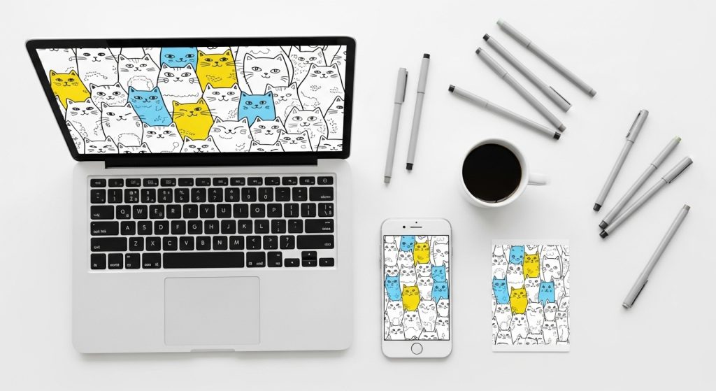 White Background with Doodle Cats: A Minimal Aesthetic for Cat Lovers 2 Flat lay of a laptop and phone showing wallpapers with doodle cats on a white background, surrounded by sketch pens and a coffee mug, super realistic, 2:3 ratio.