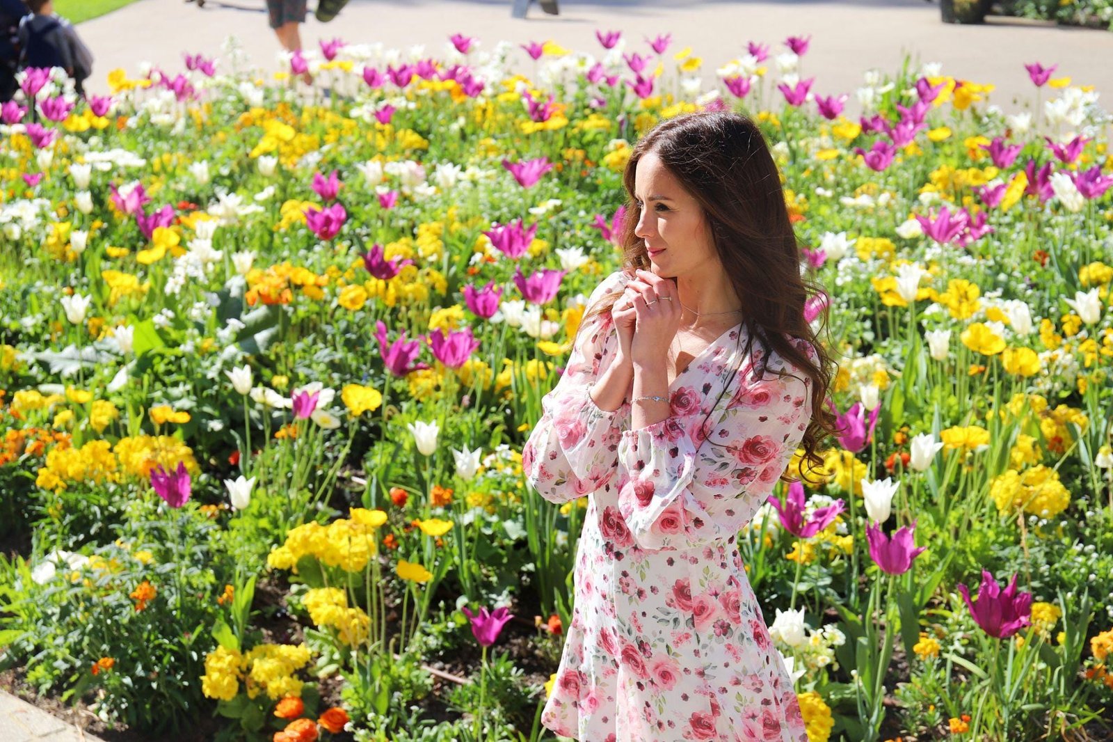 Woman wearing a pastel floral spring dress styled for a chic seasonal outfit
