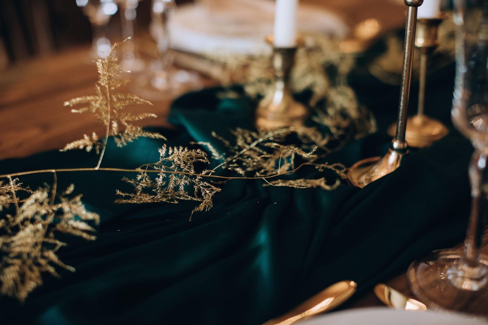 elegant emerald green wedding reception decor with gold accents and candlelight