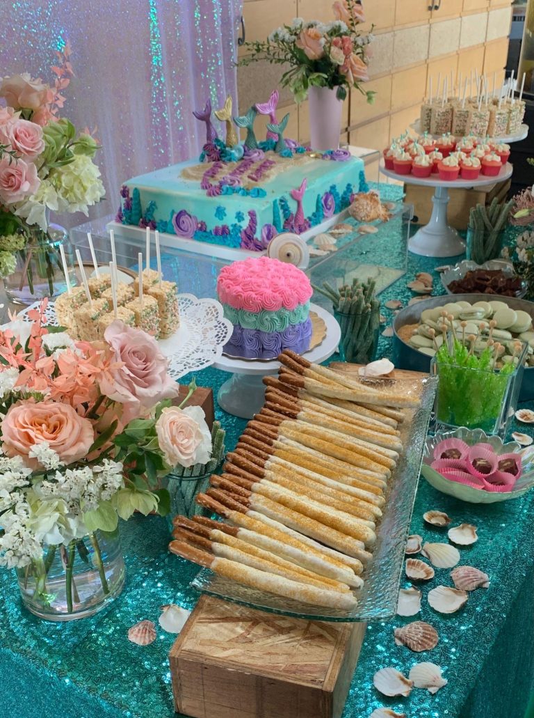 Vibrant mermaid themed birthday party setup with pastel balloons, ocean inspired decorations, seashell accents, and a luxury cake display creating a magical underwater celebration scene.