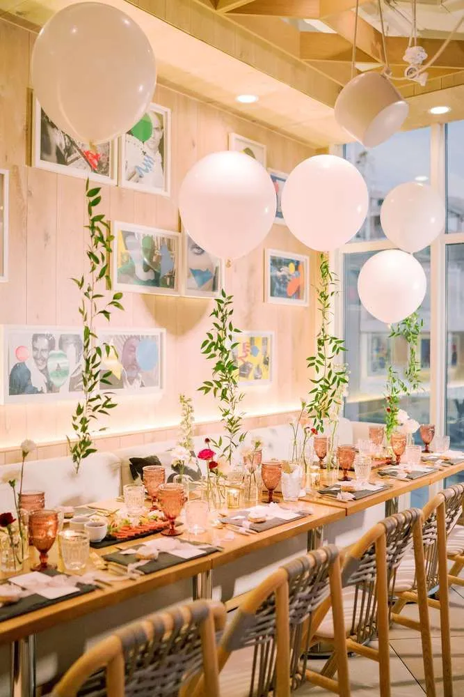 Cozy small party setup at home with candles, fairy lights, balloons, and elegant table decor creating a warm and intimate celebration.