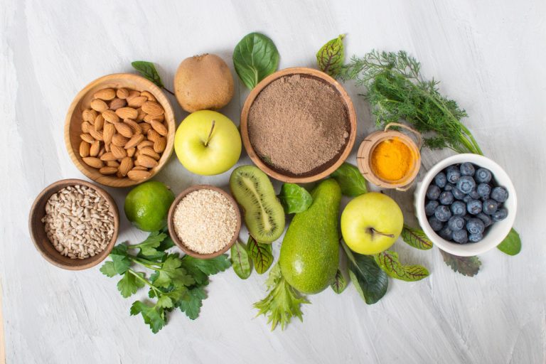 Healthy lifestyle concept showing fresh fruits, vegetables, and a glowing individual representing the connection between nutrition, natural beauty, and overall wellness.