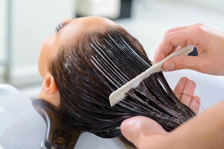 Woman applying a deep conditioning hair mask for smooth and shiny hair