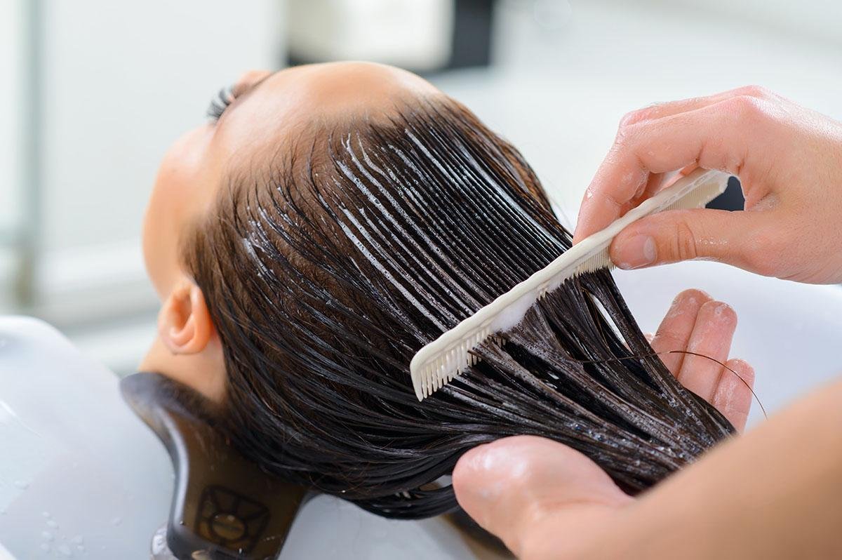 Woman applying a deep conditioning hair mask for smooth and shiny hair