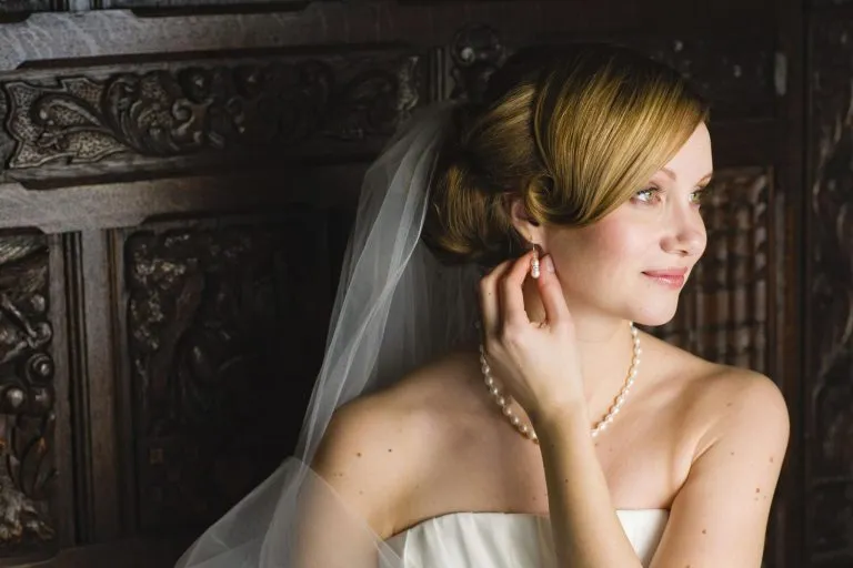 Elegant bridal beauty feature image showing a stunning bride with romantic wedding hairstyle, soft makeup, delicate veil details, and luxurious bridal fashion styling in a timeless wedding aesthetic.