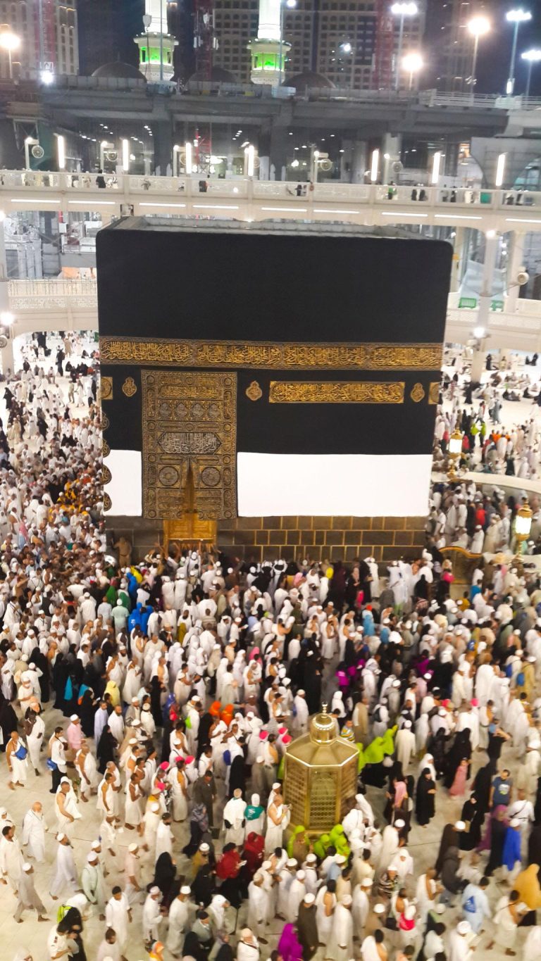 Pilgrims gathered around the Holy Kaaba at Masjid al Haram in Mecca during Hajj, creating a powerful spiritual scene filled with faith, worship, and unity under bright mosque lights at night.