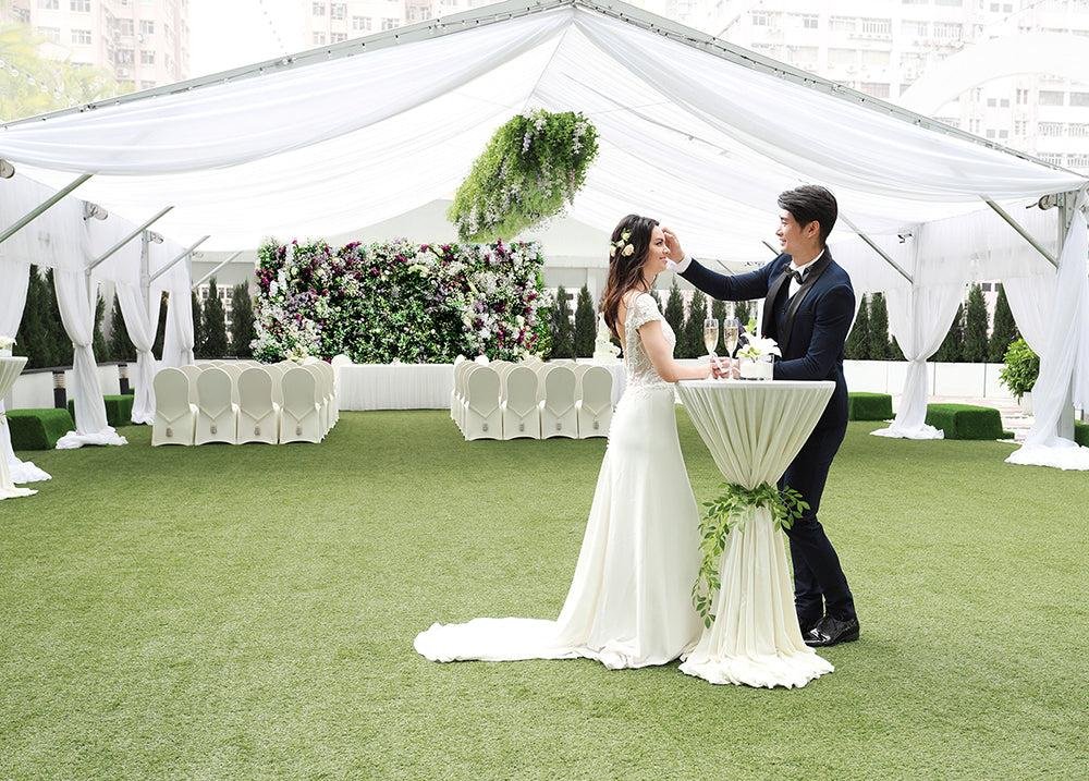 Elegant covered terrace wedding venue featuring a luxury tent, lush floral arrangements, comfortable guest seating, candlelight decor, and romantic outdoor reception styling.
