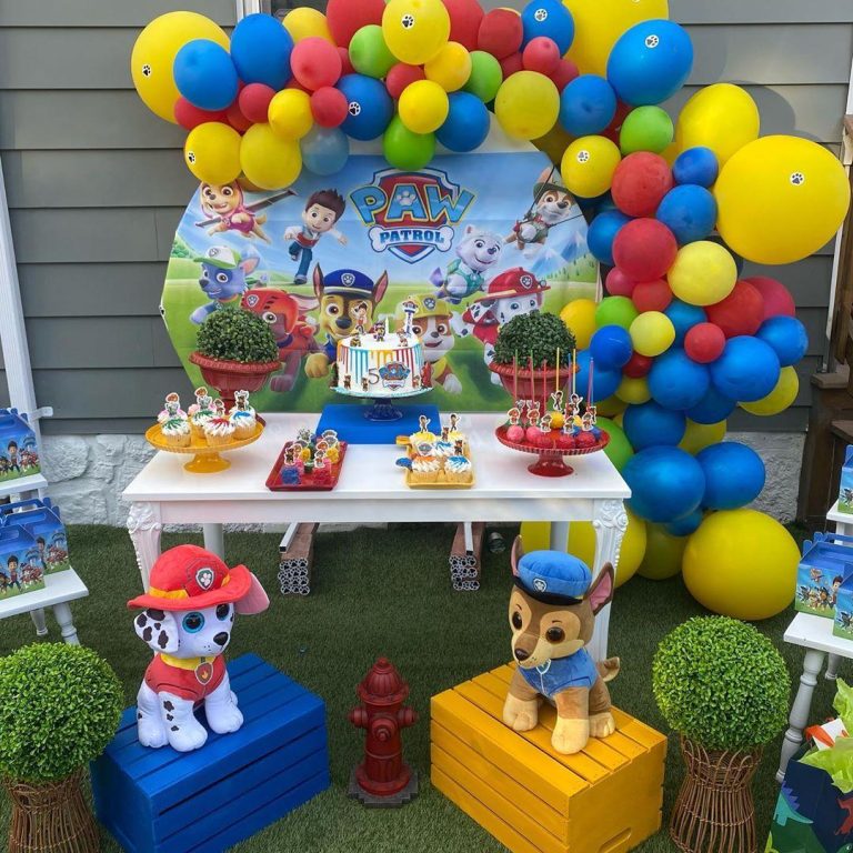 Colorful Paw Patrol birthday party setup with balloons, cake, and themed decorations.